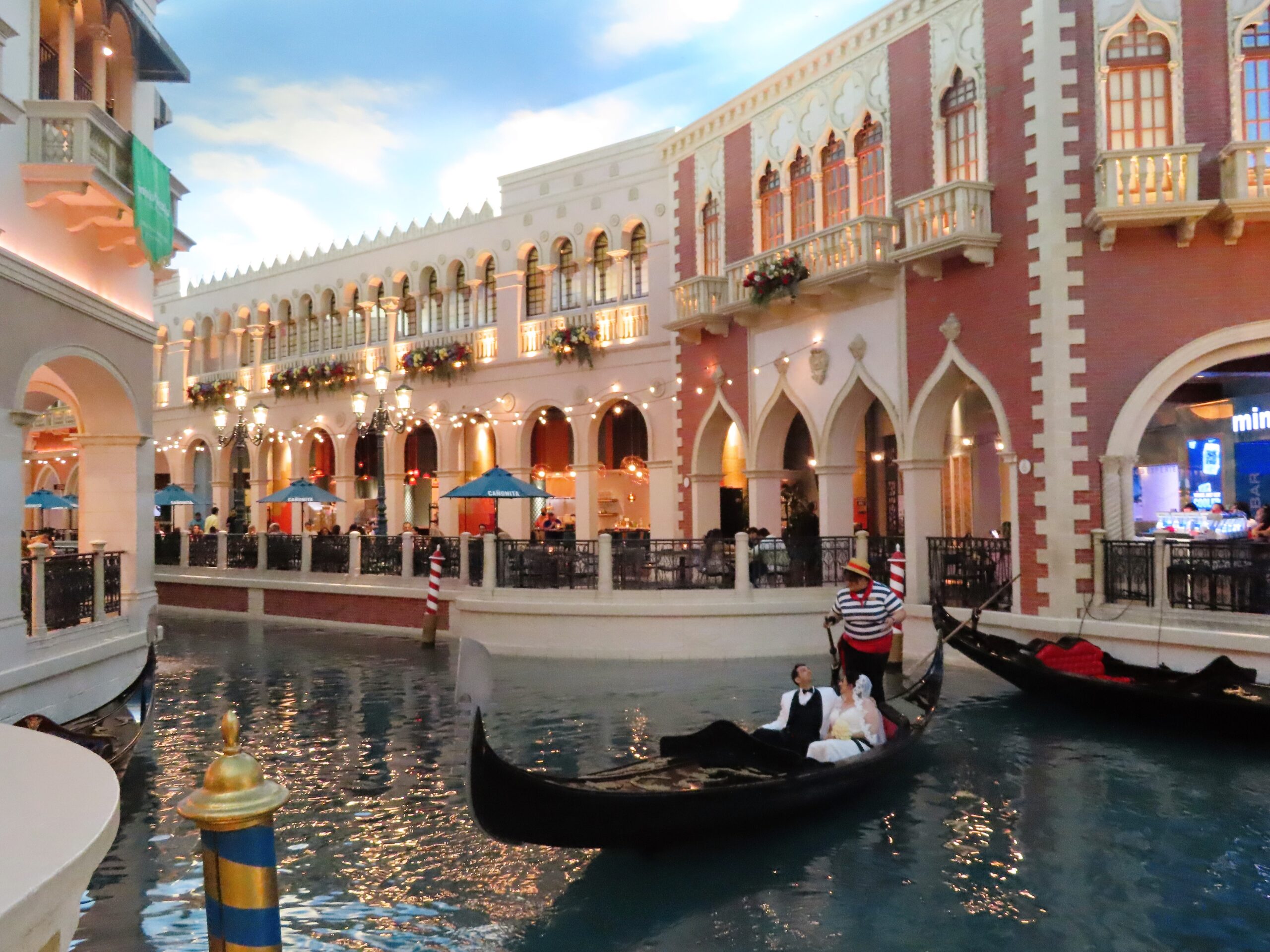 Indoor gondola ride at The Venetian Hotel in Las Vegas, with romantic lighting, faux-Venetian architecture, and a blue canal beneath a painted sky ceiling.